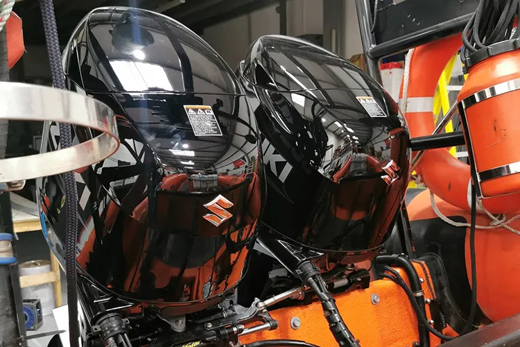 Twin Suzuki outboards fitted to a RIB Twin black Suzuki outboard engines fitted to a RIB in the Ferry Marine workshop
